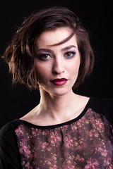 Portrait of attractive woman posing on black background in studio photo. Beauty and professional make-up