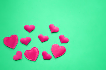 Obraz premium Pink hearts on a green background