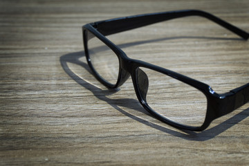 Eye glasses on the wooden table.