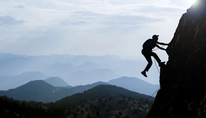 Deurstickers silhouette of a rock climber © emerald_media