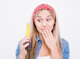 Beautiful young woman is laughing at the size shown on the measuring tape on white