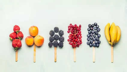 Zelfklevend Fotobehang Fruits and berries assorted popsicles on light turquoise background, top view.Healthy food and vegetarian eating concept © VICUSCHKA