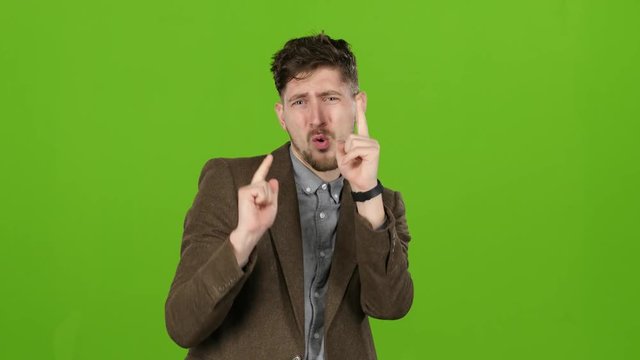 Young guy, a businessman, rejoices at his victories. Green screen