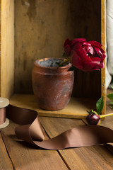 Still life with single peony flower in old, rustic vase.