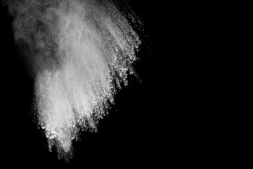 Powder explosion. Closeup of  white particle explosion isolated on black background