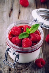 Dessert with cream cheese, raspberry sauce, fresh berries and mint