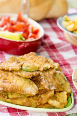 Served lunch with tomato salad and fried zucchini