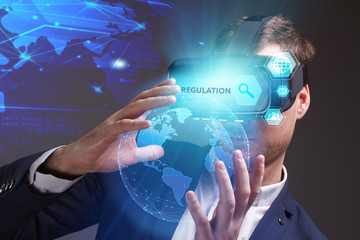 Business, Technology, Internet and network concept. Young businessman working on a virtual screen of the future and sees the inscription: Regulation