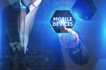 Business, Technology, Internet and network concept. Young businessman working on a virtual screen of the future and sees the inscription: Mobile devices
