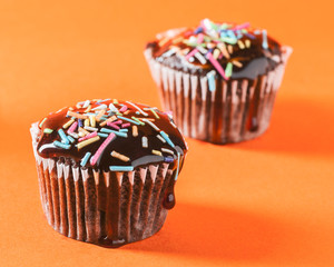 Close up of chocolate cupcakes with caramel sauce and topping