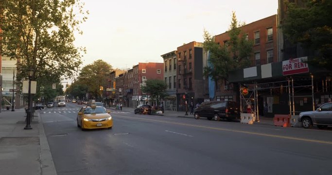 An evening establishing shot of traffic and businesses along Atlantic Avenue in Brooklyn.  	