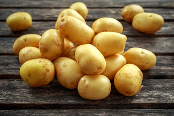 raw baby new potatoes on rustic wooden background