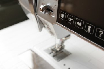 control buttons and touchscreen of a modern computerised sewing machine - background blanked out blurry