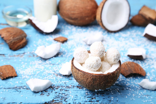 Coconuts with candies on blue wooden table