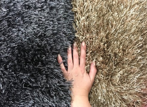 frauen hand zwischen zwei teppichen 