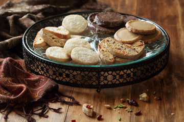 Biscotti and Different Shortbread Cookies on big plate, on wooden background.