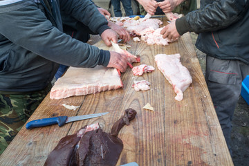 Hands cutting raw meat on market - outdoors, sale, cuisine, traditional
