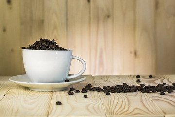 coffee beans in cup with  wooden background and effect filter.