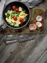 Omelette with ripe tomatoes in rustic pan, topview