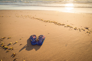 Fototapeta na wymiar Aussie thongs on the beach at sunset
