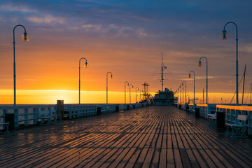 The first rays of the sun warms the wet boards of the pier in Sopot. Poland.