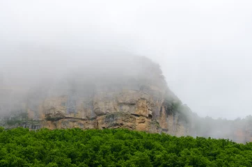 Foto op Canvas Haze fog over the rocks. Cloud over the mountainin Caucasus. Green leaf forest. Mezmay and Guamka © Boris