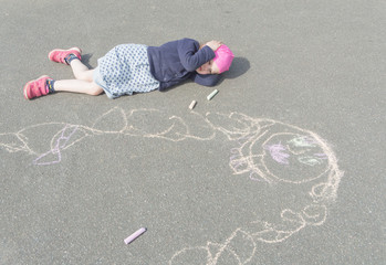 baby girl lying on the pavement thinking about mom.