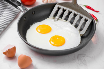 Fried eggs in a frying pan with cherry tomatoes and bread for breakfast