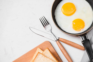 Top view of traditional healthy easy quick breakfast meal made of fried eggs served on a frying pan.