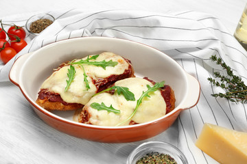 Chicken parmesan with spices in baking dish on table