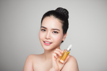 Obraz na płótnie Canvas Beauty concept. Asian pretty woman with perfect skin holding oil bottle