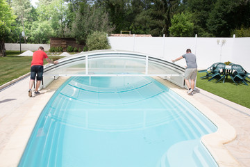 Two men open family private pool for swimming in summer