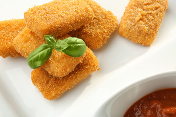 Cheese sticks with basil and tomato sauce on plate