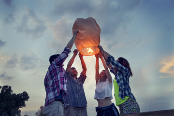 Group of young friends floating on a Chinese lantern © Marino Bocelli