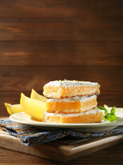 Delicious lemon pie bars stack on wooden background,close up