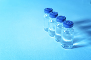 Medical ampules on colour background. Vaccination concept