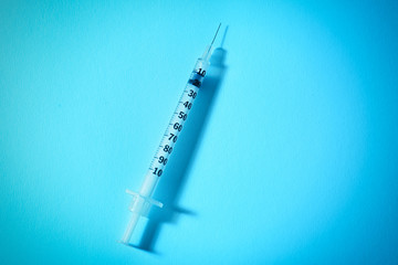 Medical syringe on color background