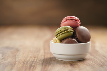 assorted macarons in white bowl on wooden table - Powered by Adobe