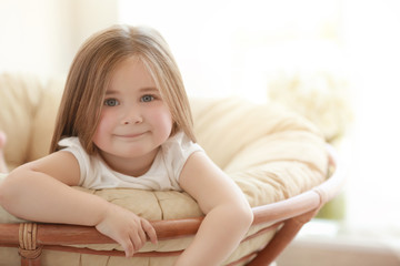 Obraz na płótnie Canvas Cute little girl resting on lounge at home