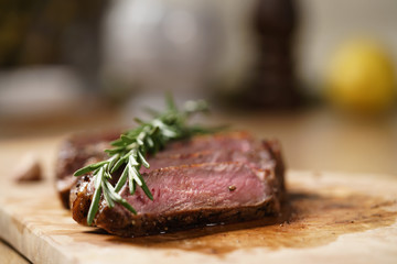 sliced medium rib eye steak with rosemary branch