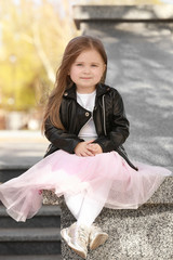Little fashionable girl in park on spring day
