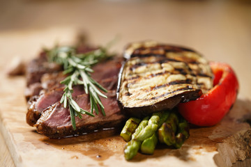 sliced medium rib eye steak with grilled vegetables