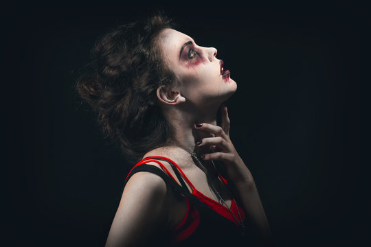 Young woman with Halloween makeup on dark background