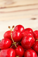 Red ripe juicy sweet cherry lies on vintage wooden background. Sweet summer berries.