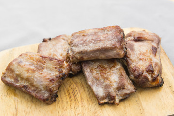 grilled pork rib on wooden cutting board, close up