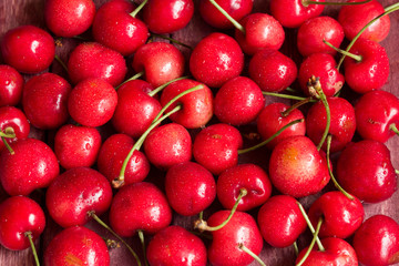 Red ripe juicy sweet cherry lies on vintage wooden background. Sweet summer berries.