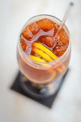 ice lemon tea in a atall glass with three lemon slices
