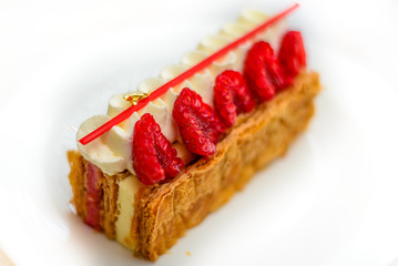 Vanilla and Raspberry Mille feuille pastry cake on white china plate