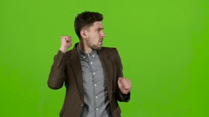 Boy a businessman, rejoices at his victories. Green screen. Slow motion