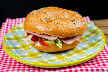 Bagel with fresh cheese and fresh lettuce on napkin